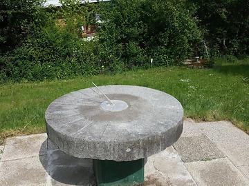 Mühlstein mit horizontaler Sonnenuhr in Pressbaum zeigt 14 Uhr