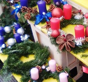 Adventskränze mit dunkelblaue, rosarote und zartrosa Kerzen, mit Tannenzapfen, Kugeln …, vor einem Floristengeschäft Adventskränze mit dunkelblaue, rosarote und zartrosa Kerzen, mit Tannenzapfen, Kugeln …, vor einem Floristengeschäft