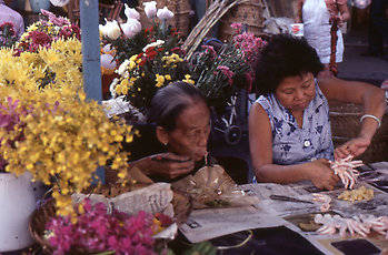 Eating some noodles from the paper with sticks Eating some noodles from the paper with sticks